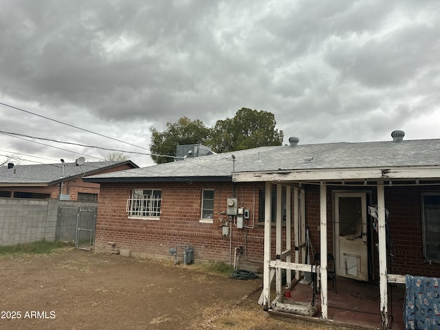 back of property with brick siding and fence