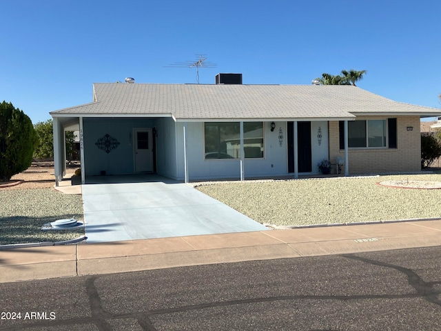 ranch-style house featuring cooling unit and a carport