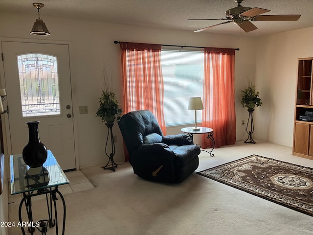 carpeted entryway with ceiling fan and a textured ceiling