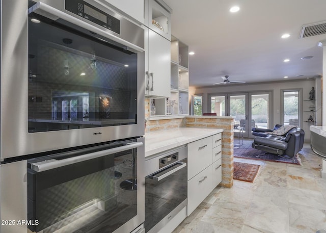 kitchen with white cabinets, french doors, double oven, and ceiling fan