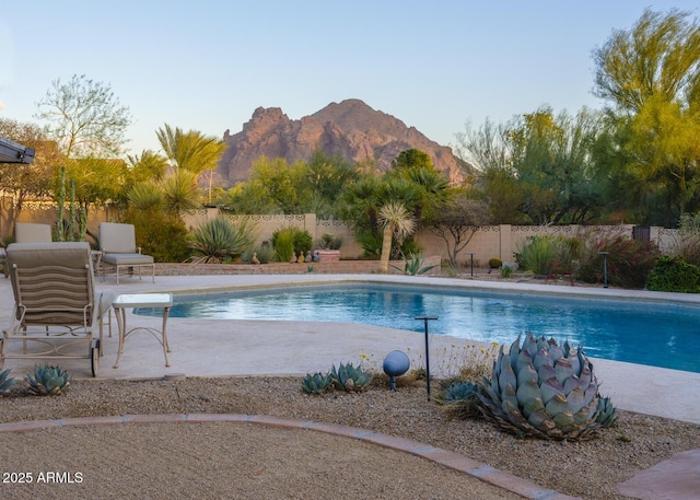 view of swimming pool with a mountain view and a patio area