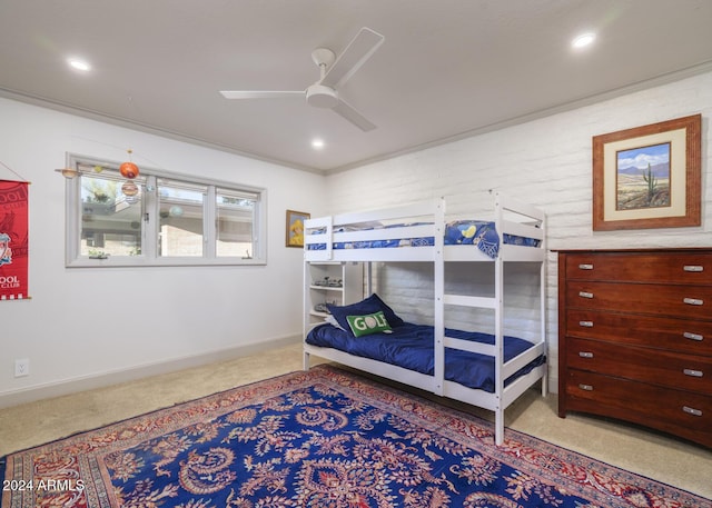 carpeted bedroom with ceiling fan and ornamental molding