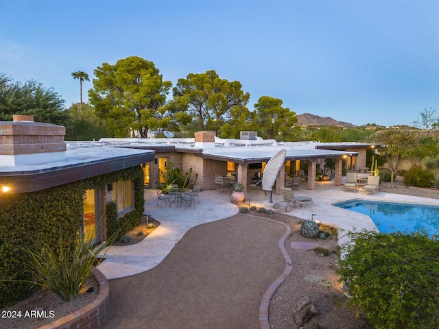 back of property featuring a mountain view and a patio