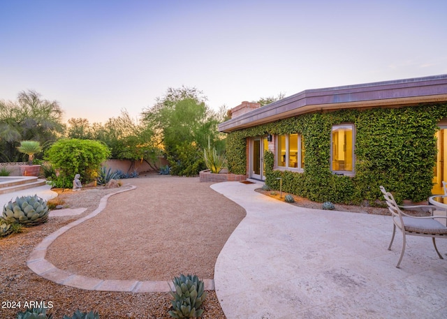 yard at dusk with a patio area