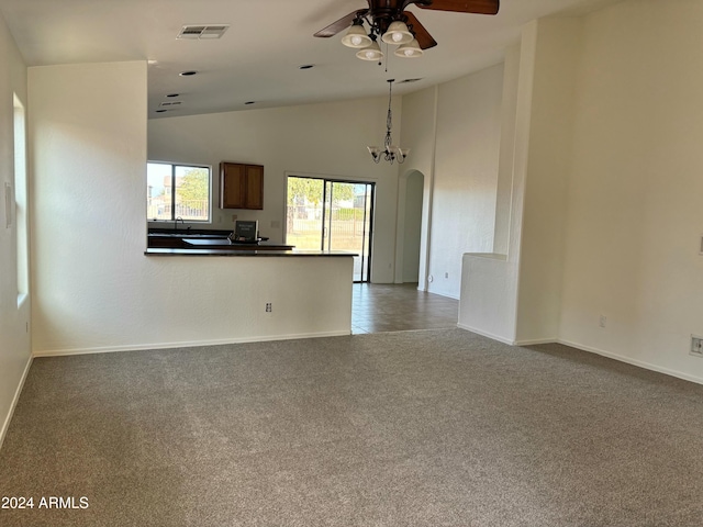 unfurnished living room featuring sink, carpet, ceiling fan with notable chandelier, and high vaulted ceiling