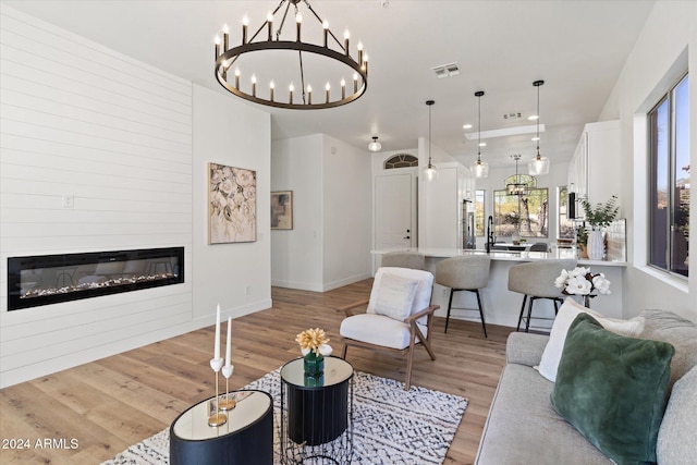 living room featuring light wood-type flooring and a chandelier