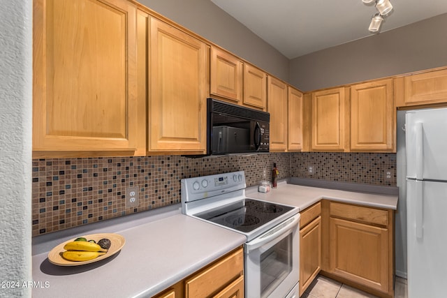 kitchen with fridge, white electric range, light tile patterned flooring, and decorative backsplash