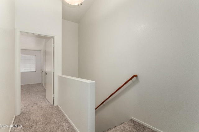 hall with light colored carpet and vaulted ceiling