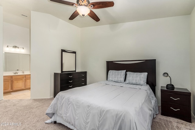 carpeted bedroom with ensuite bath, ceiling fan, and sink