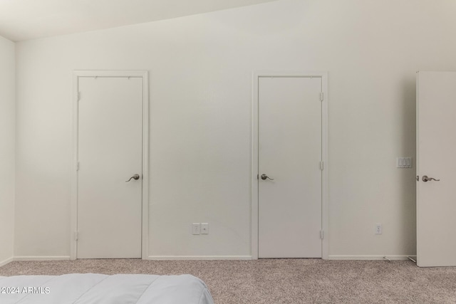 unfurnished bedroom with lofted ceiling and light colored carpet