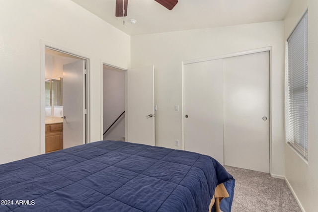 carpeted bedroom with ensuite bathroom, ceiling fan, and a closet