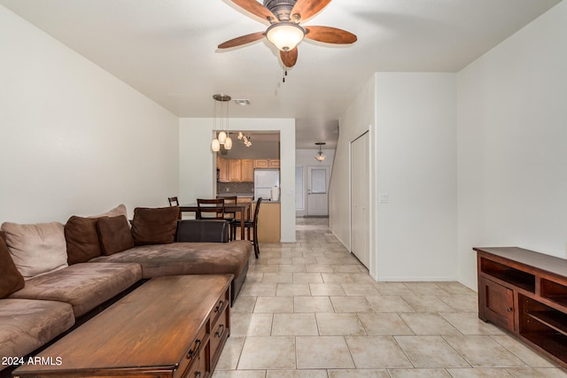 tiled living room with ceiling fan with notable chandelier