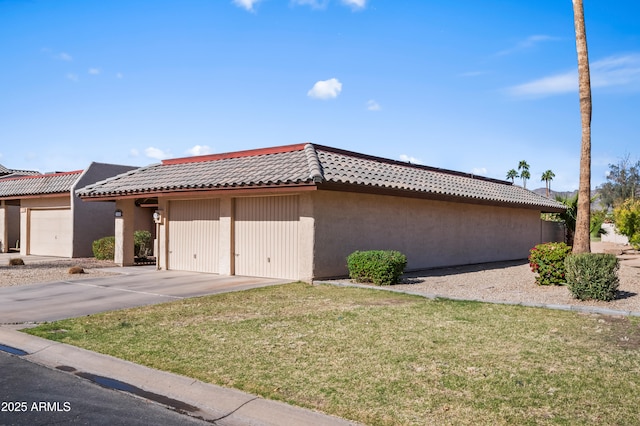 view of property exterior featuring a tile roof, a lawn, and stucco siding