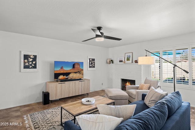 living area with a brick fireplace, baseboards, and ceiling fan