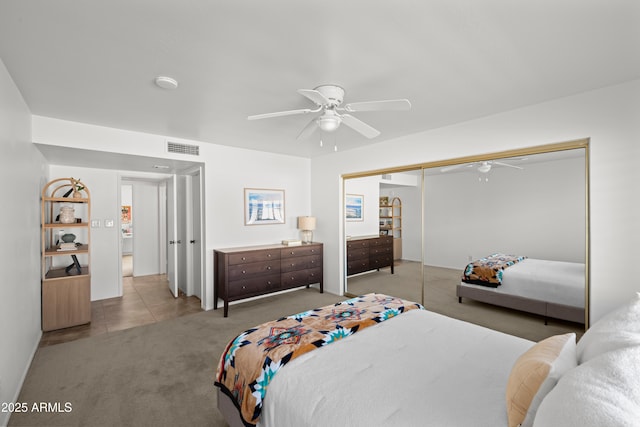 bedroom featuring visible vents, light colored carpet, a closet, and ceiling fan