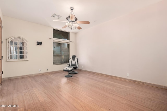 exercise area featuring ceiling fan and light hardwood / wood-style flooring