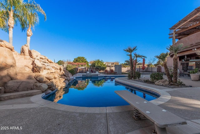 view of swimming pool featuring a diving board and a patio area