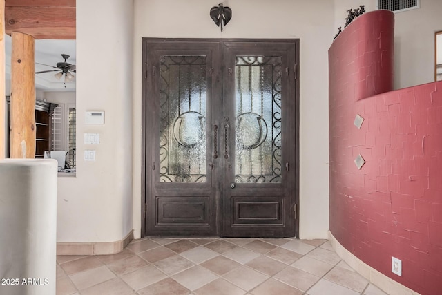 tiled foyer featuring ceiling fan and french doors