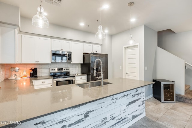 kitchen with tasteful backsplash, appliances with stainless steel finishes, pendant lighting, beverage cooler, and white cabinets