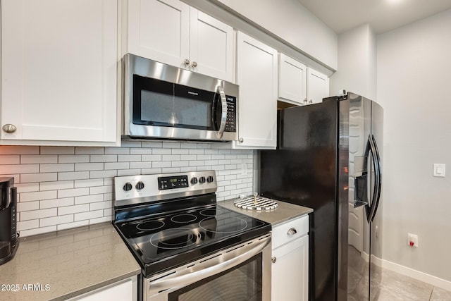 kitchen with stone counters, stainless steel appliances, decorative backsplash, and white cabinets