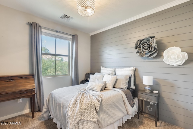 carpeted bedroom featuring ornamental molding and wooden walls