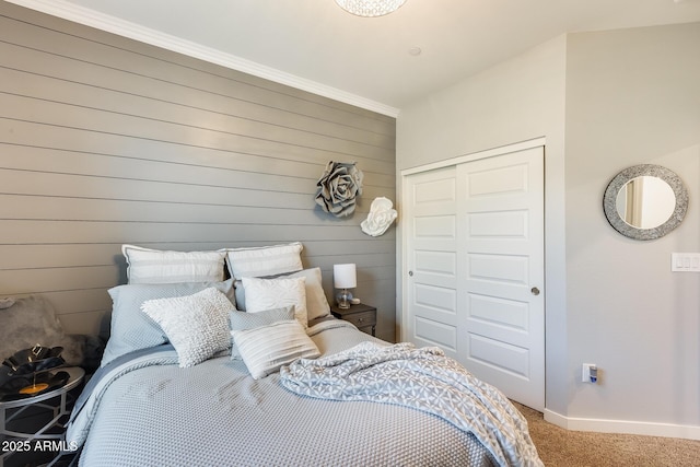 carpeted bedroom featuring crown molding and a closet