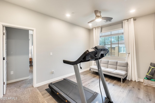 exercise area with ceiling fan and light wood-type flooring