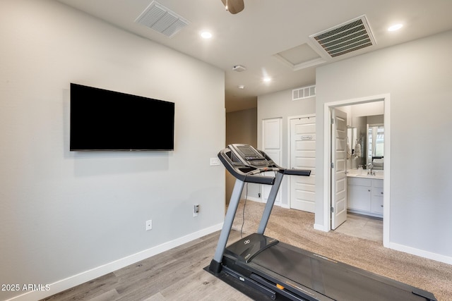 exercise room with light wood-type flooring