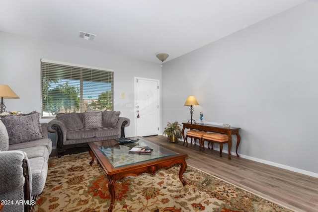 living area with visible vents, baseboards, and wood finished floors