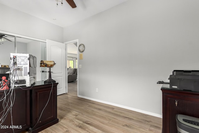 home office with baseboards, a ceiling fan, and light wood-style floors