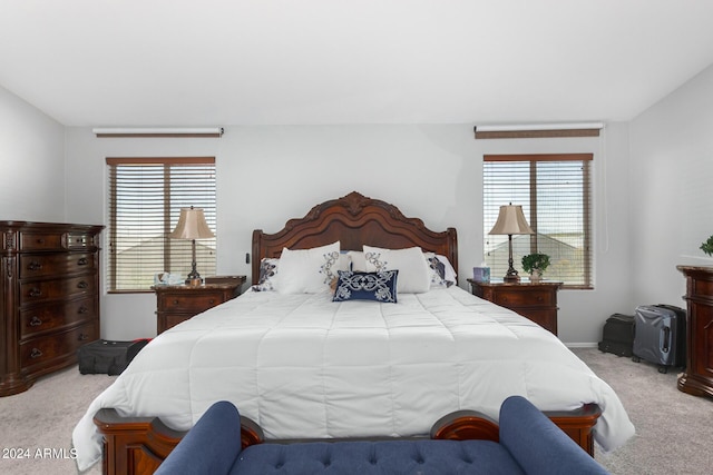 bedroom with multiple windows and light colored carpet