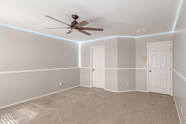 unfurnished room with a ceiling fan, light carpet, visible vents, and baseboards