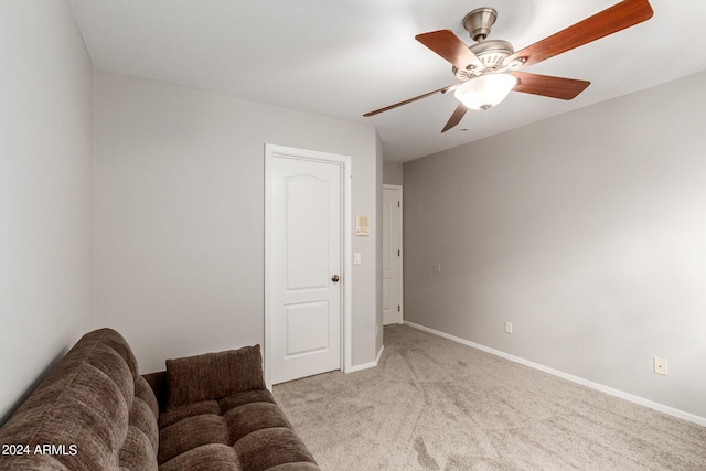 living area featuring a ceiling fan, light colored carpet, and baseboards