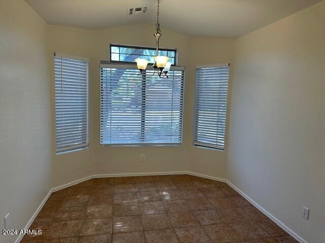 unfurnished dining area featuring a notable chandelier and vaulted ceiling