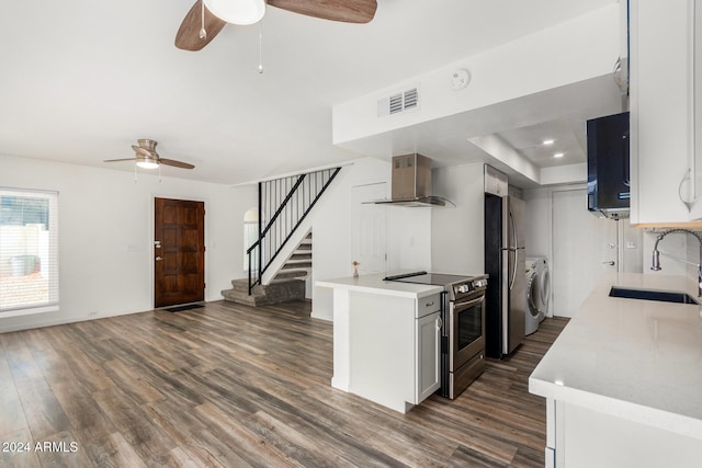 kitchen featuring washer / clothes dryer, appliances with stainless steel finishes, sink, wall chimney exhaust hood, and dark wood-type flooring