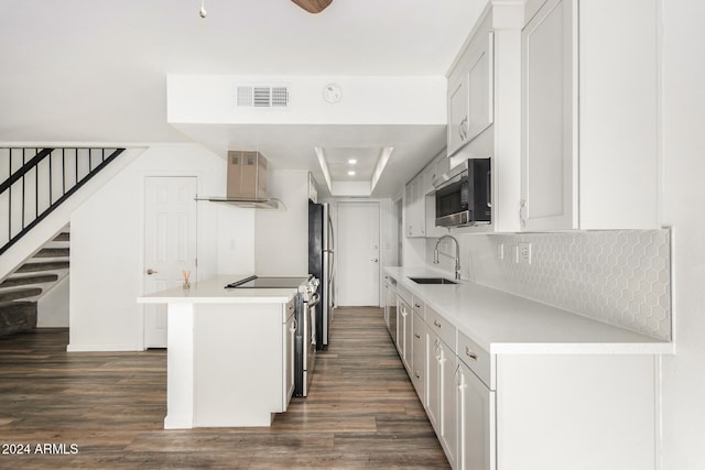 kitchen featuring wall chimney exhaust hood, sink, appliances with stainless steel finishes, and white cabinetry