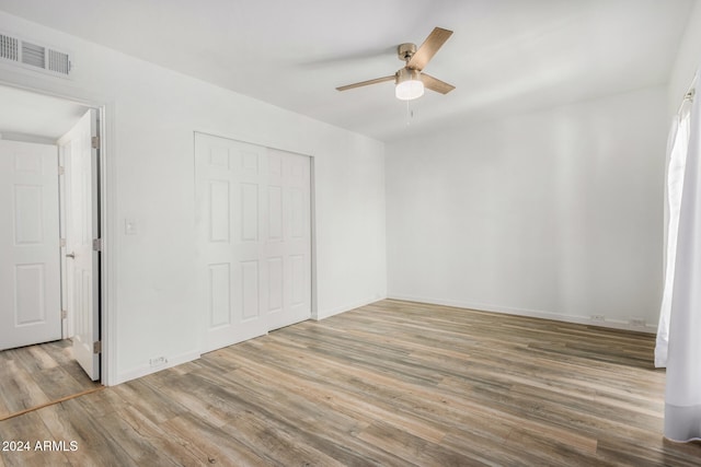 unfurnished bedroom with a closet, ceiling fan, and hardwood / wood-style floors