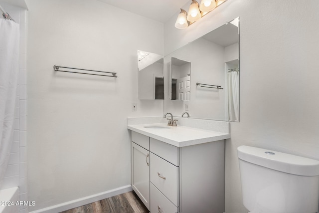 bathroom with toilet, hardwood / wood-style flooring, and vanity