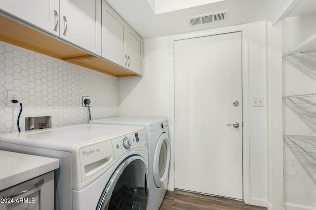 washroom with washer and dryer, cabinets, and dark hardwood / wood-style floors