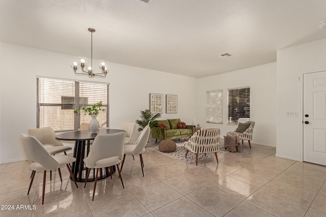 tiled dining area featuring a chandelier