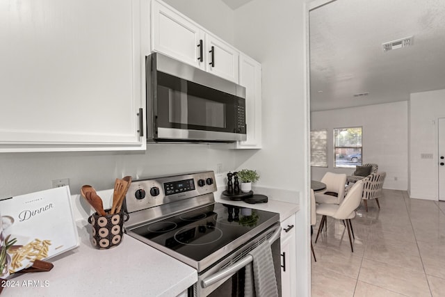 kitchen featuring white cabinetry, stainless steel appliances, and light tile patterned floors