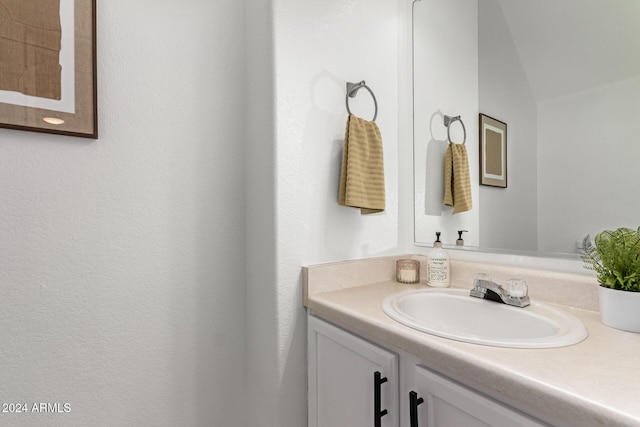 bathroom with vanity and lofted ceiling