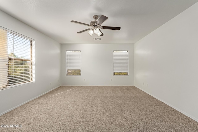 carpeted spare room with ceiling fan