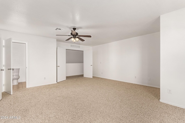 unfurnished bedroom featuring carpet, ceiling fan, and ensuite bathroom