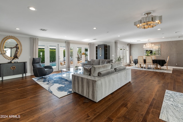 living room with a chandelier, french doors, crown molding, and dark wood-type flooring