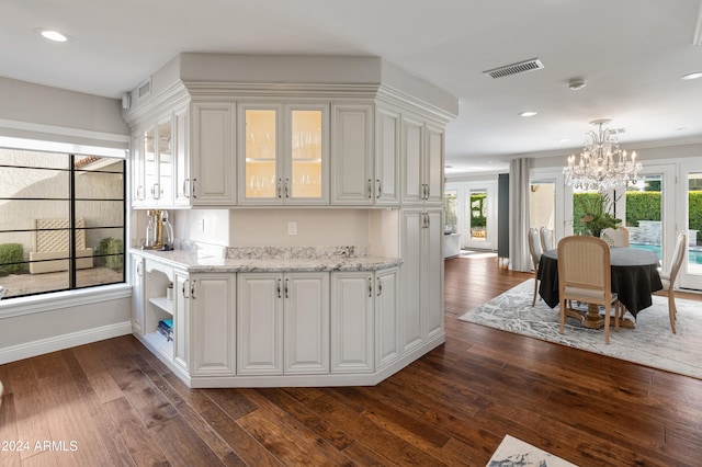 bar with pendant lighting, white cabinetry, dark wood-type flooring, and a wealth of natural light