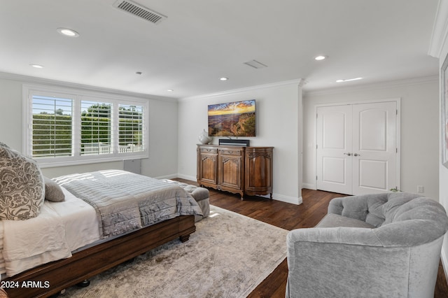 bedroom with ornamental molding, dark wood-type flooring, and a closet