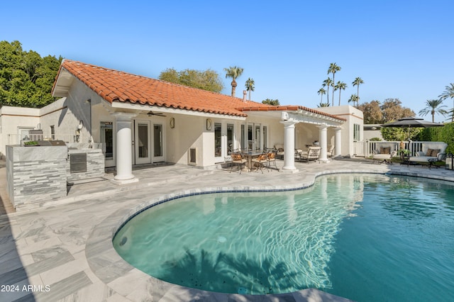 back of property featuring ceiling fan, french doors, a patio, and an outdoor kitchen