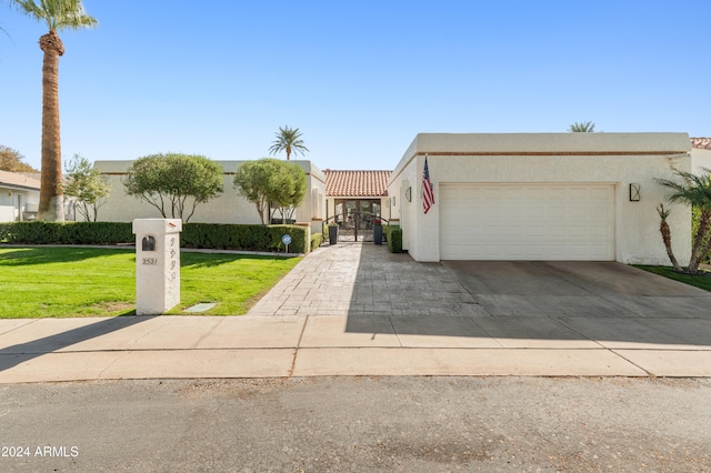 view of front of home with a front yard and a garage