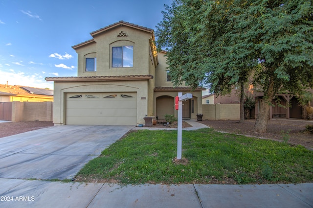 mediterranean / spanish-style house with a front yard and a garage